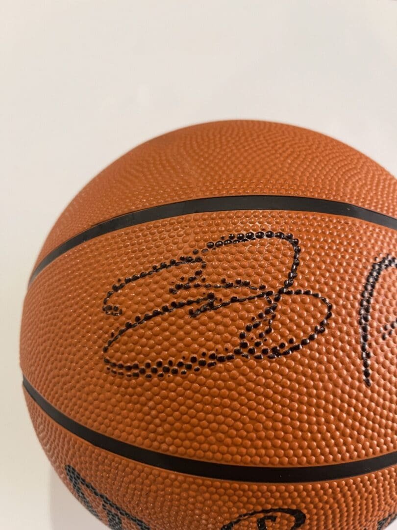Signed basketball with black marker signature.