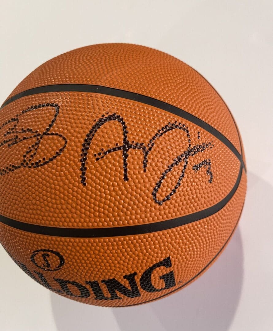 Autographed Spalding basketball on white background.