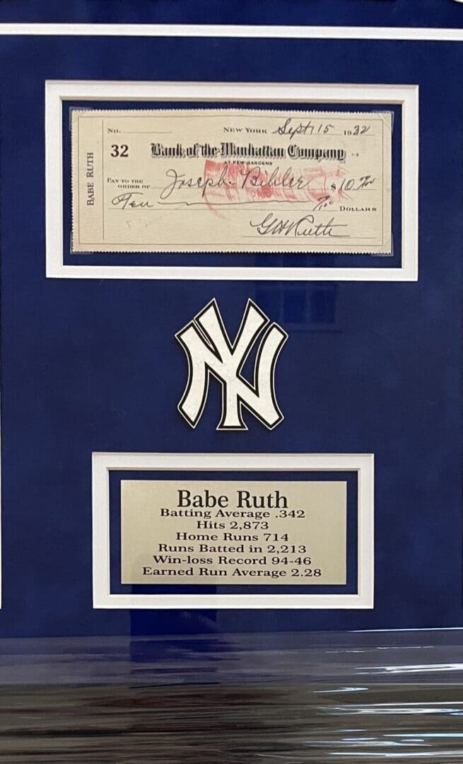 Framed Babe Ruth memorabilia with check and stats.