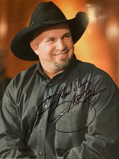 Man in black cowboy hat smiling.