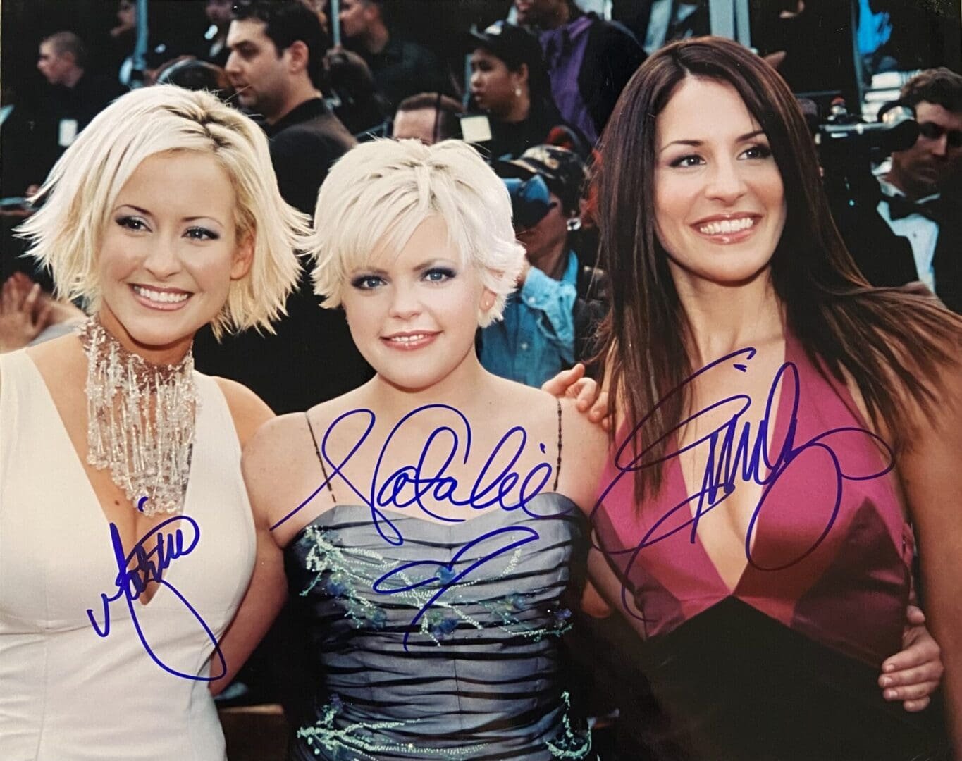 Three women smiling at an event.