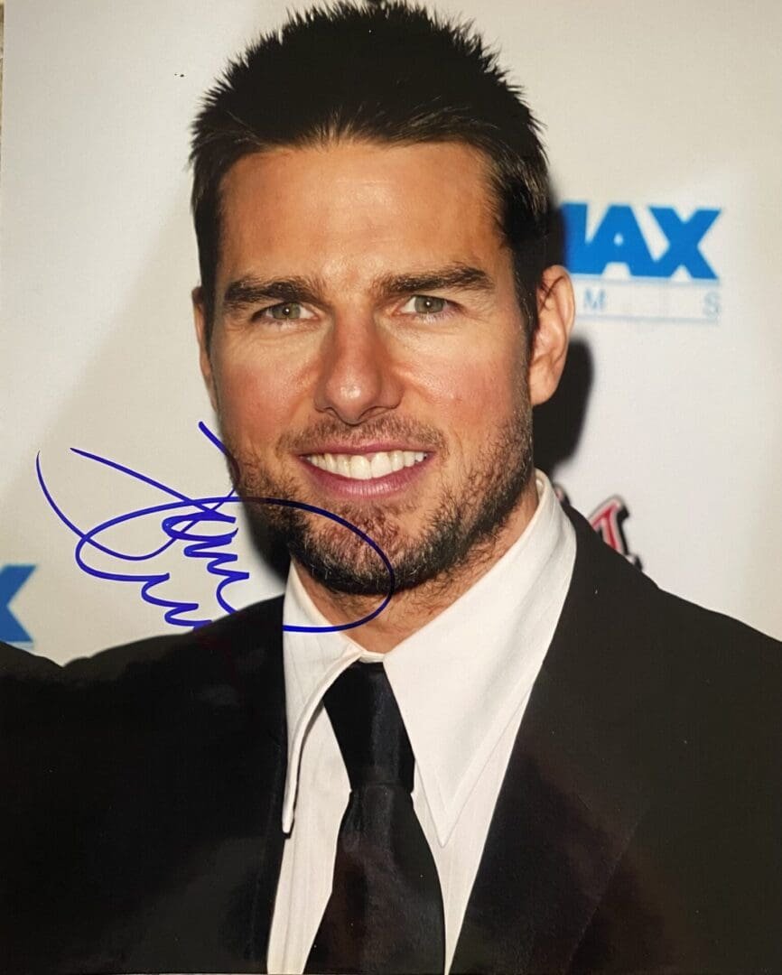 Man in suit with autograph on photograph.