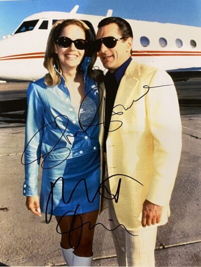 Couple in sunglasses posing by private jet.