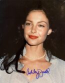 Smiling woman with dark hair and pearls.