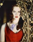 Woman in red dress beside ornate mirror.