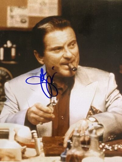 Man in suit smoking cigar at desk.