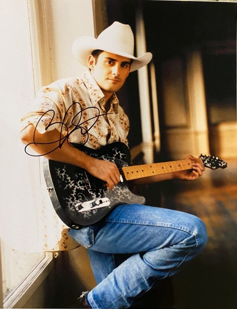 Man in cowboy hat playing electric guitar.