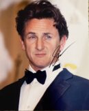 Man in tuxedo with autographed photograph.