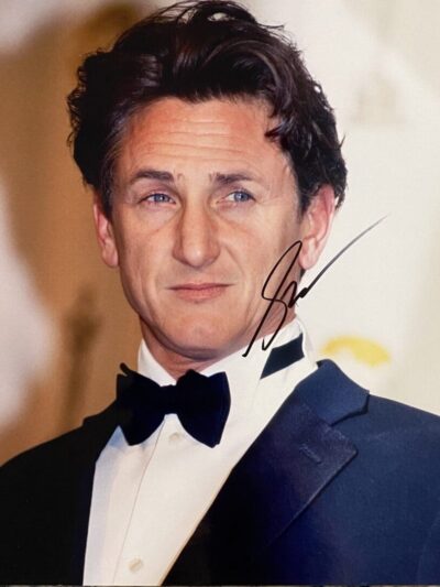 Man in tuxedo with autographed photograph.
