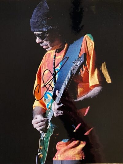 Guitarist performing in colorful shirt on stage.