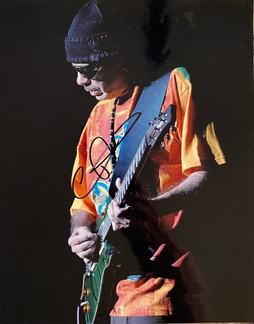 Guitarist performing in colorful shirt on stage.