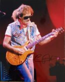Guitarist performing on stage with electric guitar.