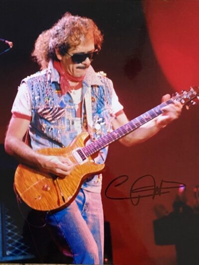Guitarist performing on stage with electric guitar.