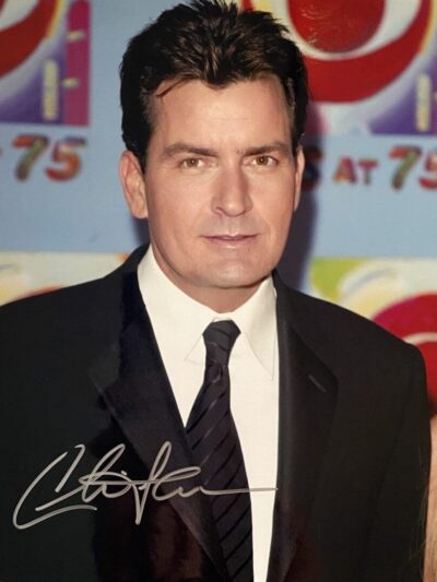 Man in suit with autograph on photo.