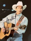 Man in cowboy hat playing acoustic guitar.