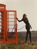 Woman in black outfit by red phone booth.
