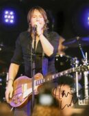 Musician performing on stage with guitar.