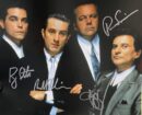 Four men in suits with autographs.