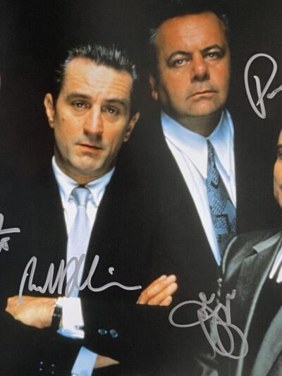 Four men in suits with autographs.