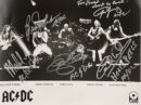 Band performing on stage with autographs.