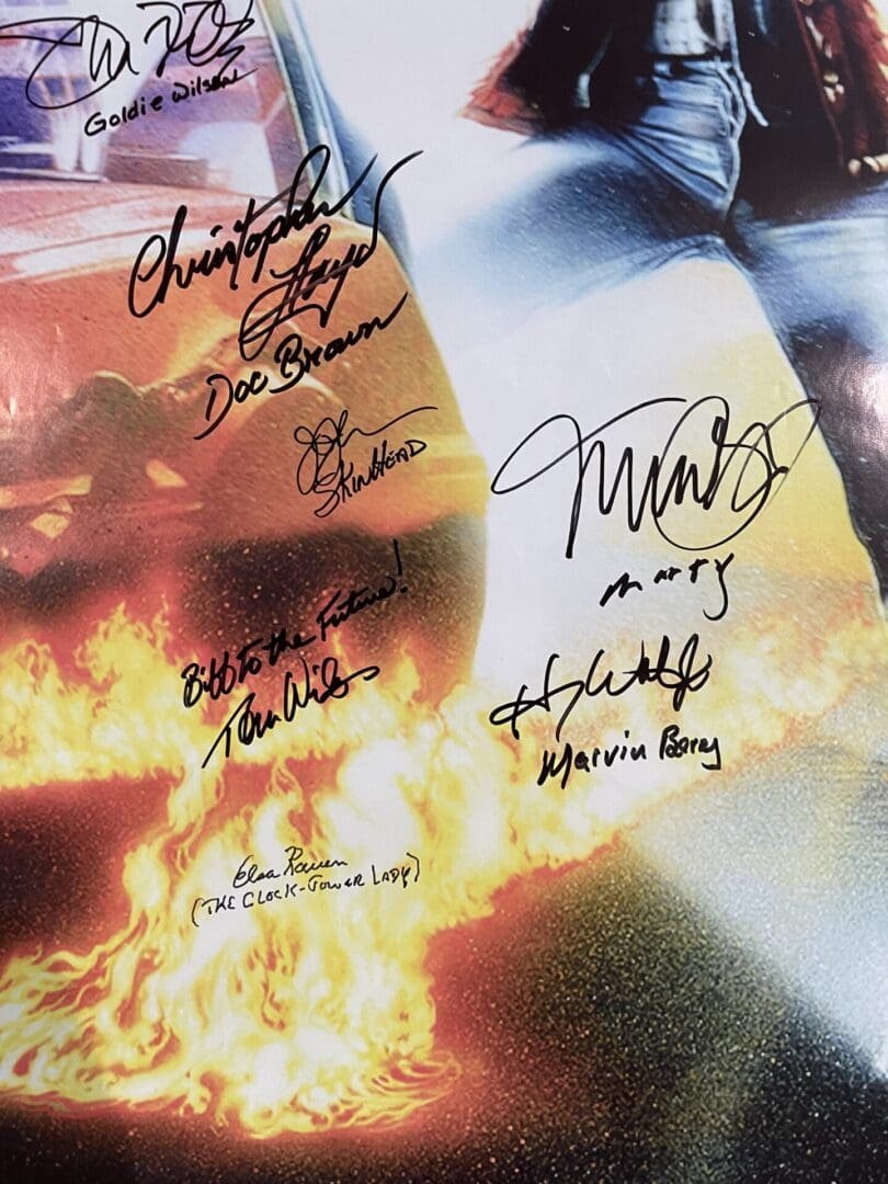 Autographed poster with flames and signatures.