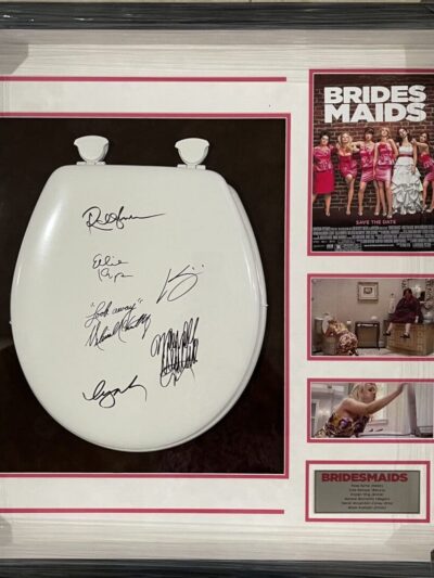 Framed autographed toilet seat with Bridesmaids poster.