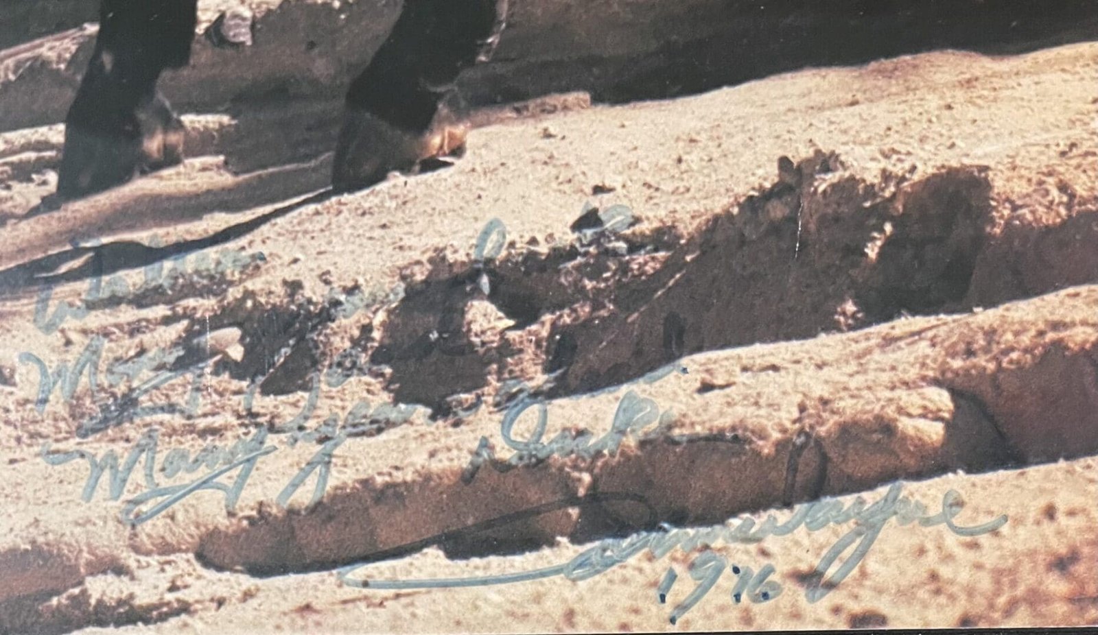 Rocky terrain with faint handwritten text overlay.