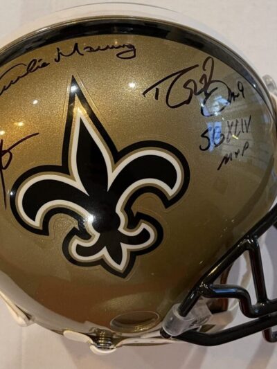 Gold football helmet with multiple autographs.