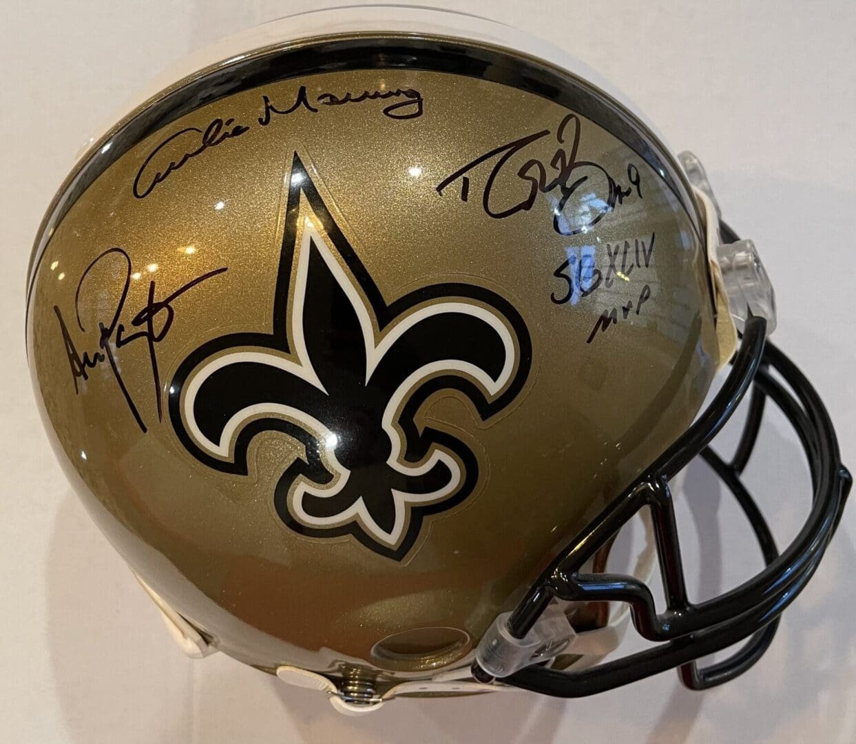 Gold football helmet with multiple autographs.