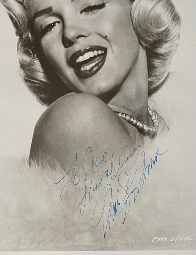 Smiling woman with autograph on photograph.