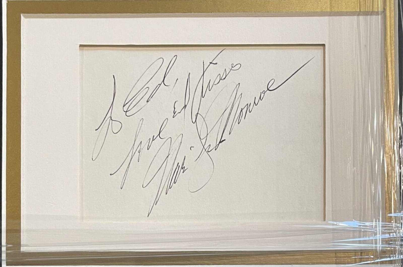 Framed handwritten note with elegant script.