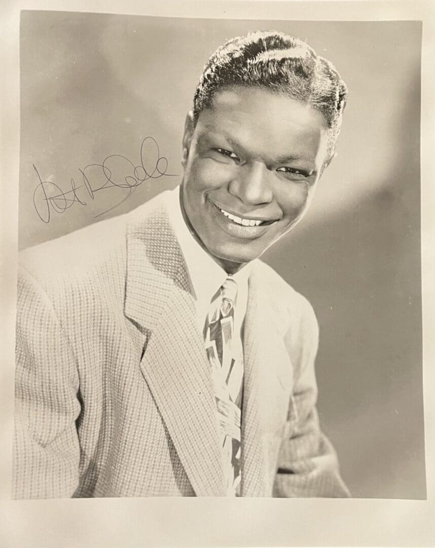 Smiling man in suit with autograph.