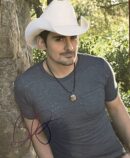 Man wearing cowboy hat near a tree.