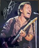 Singer passionately performing on stage with guitar.