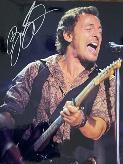 Singer passionately performing on stage with guitar.