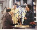 Three men talking in a kitchen scene.