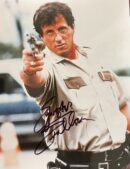 Actor in uniform pointing a gun forward.