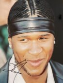 Smiling man with braids and headband.