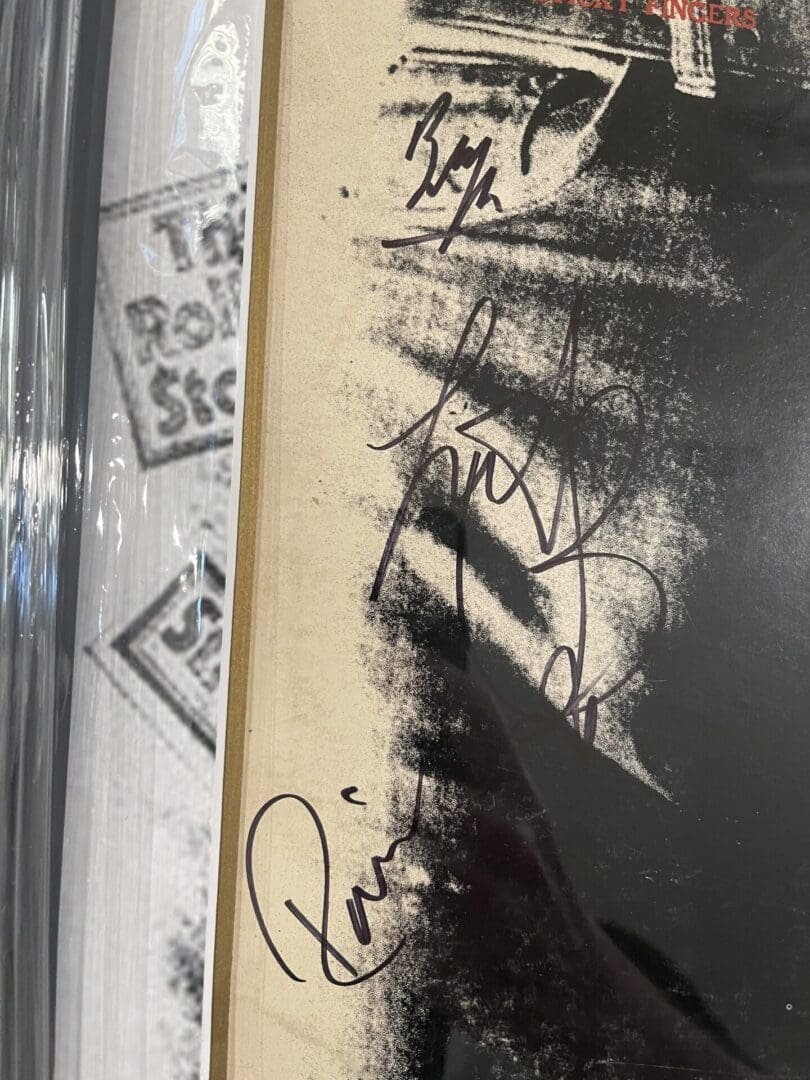 Autographed album cover with multiple signatures.