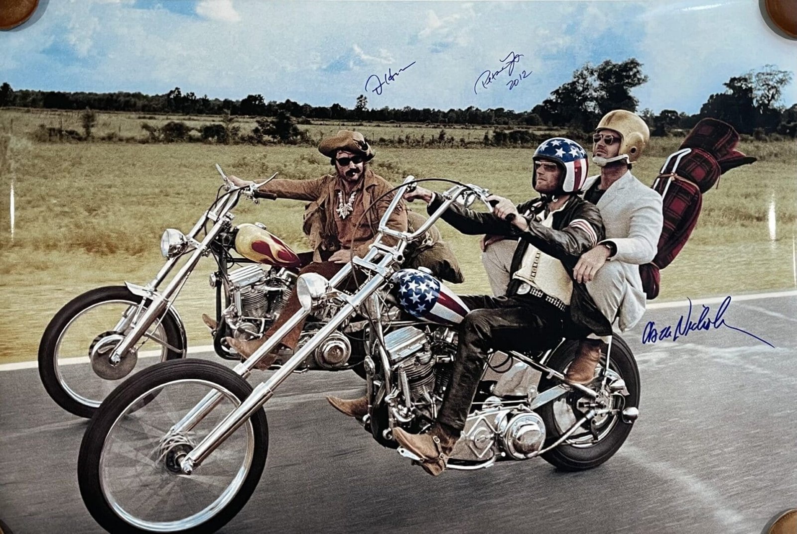 Three men riding motorcycles on an open road.