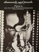 Close-up portrait with beads and autograph.