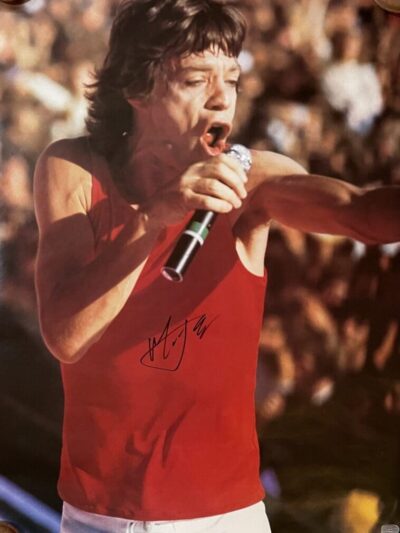 Singer performing energetically in red tank top.