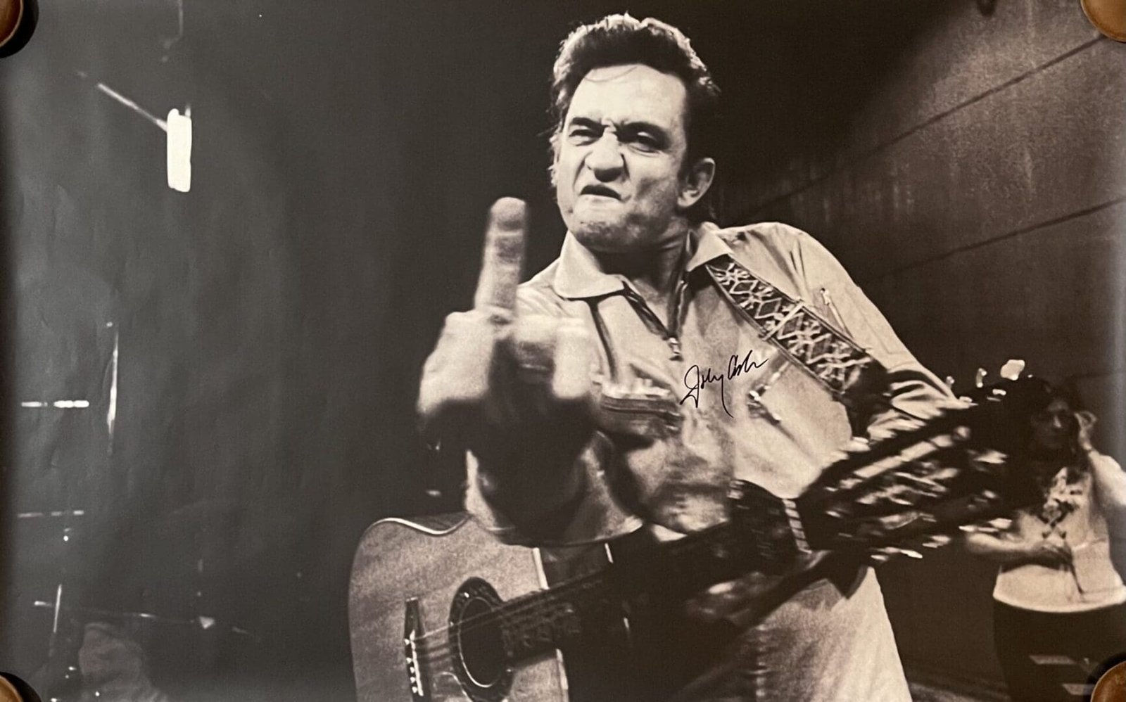 Musician with guitar making bold gesture.