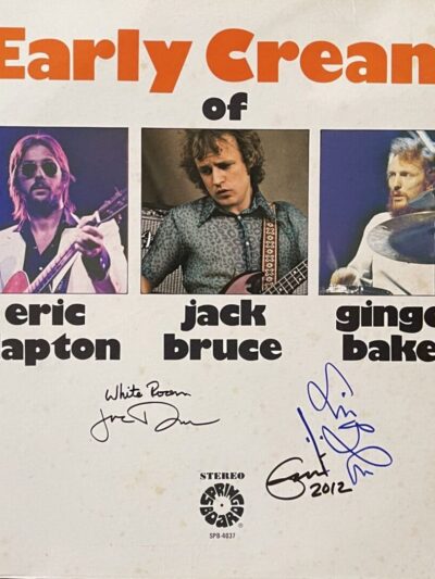 Album cover with three musicians and signatures.