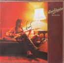 Guitarist playing on couch with lamp.