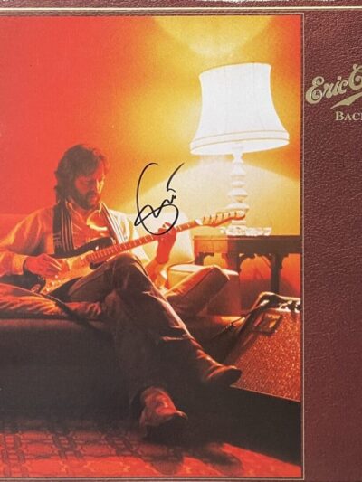 Guitarist playing on couch with lamp.