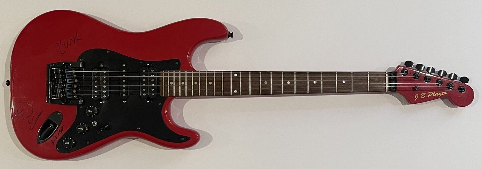 Red electric guitar with black pickguard.