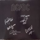 Signed AC/DC album cover with autographs.