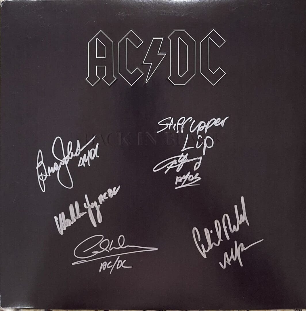 Signed AC/DC album cover with autographs.