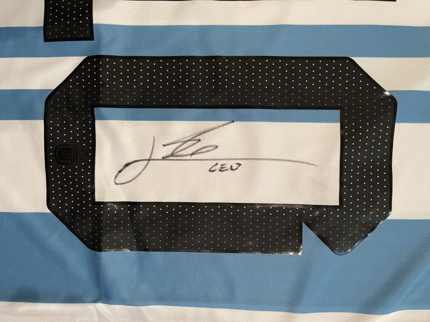 Signed sports jersey with blue stripes.